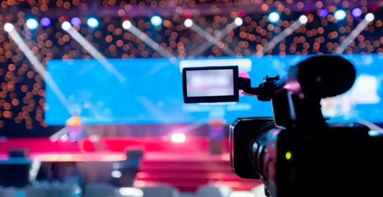 Camera focused on a stage with vibrant bokeh lights.